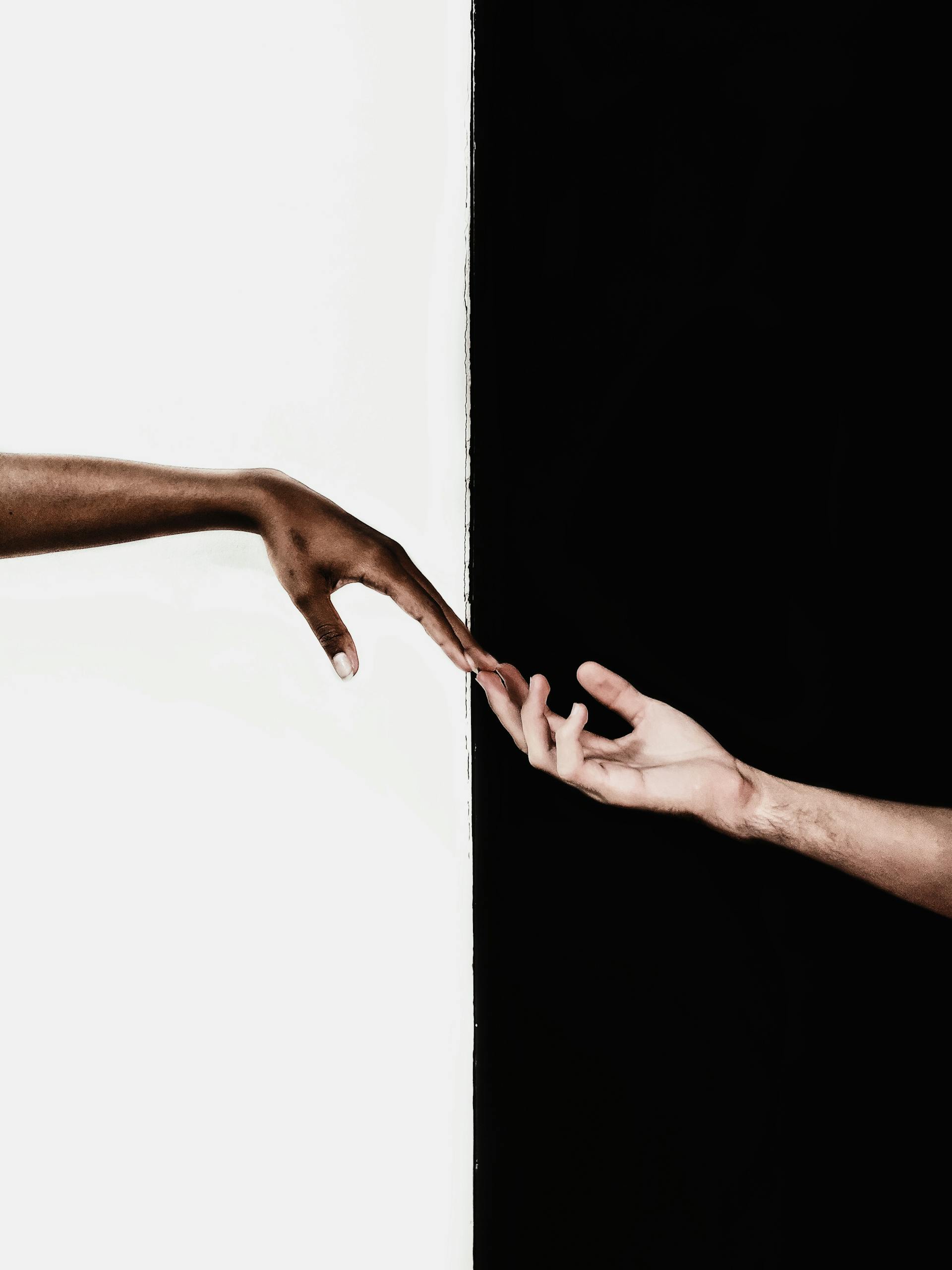 Symbolic image of two hands reaching toward each other, representing unity and diversity.