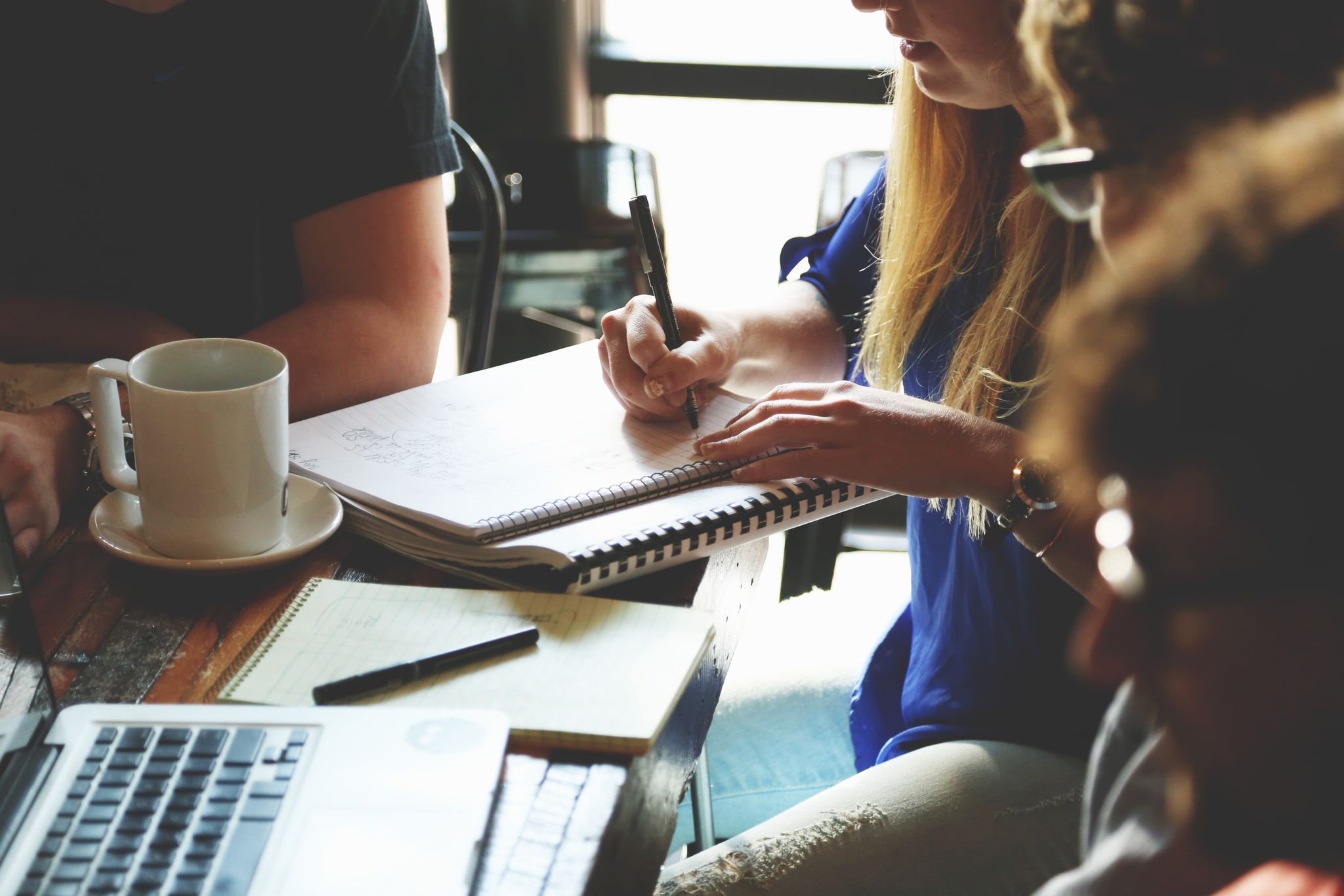 A group of young adults working together on a project at a casual meeting.